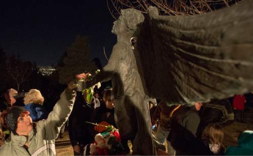 Rick Egan  |  The Salt Lake Tribune

Tisha Hamelin, places a rose on the angel,  during the annual ceremony for grieving parents at the Christmas Box Angel, at the Salt Lake City Cemetery, Saturday, December 6, 2014
