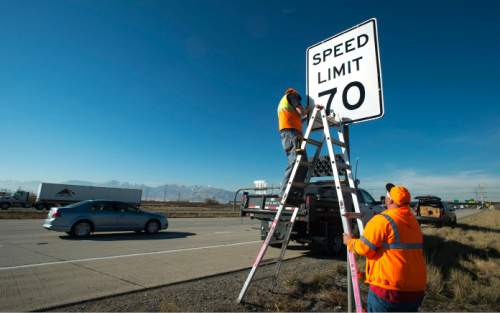 Steve Griffin  |  The Salt Lake Tribune

UDOT's Jayson Kesler, right, and Stephan Foster install a new 70 mph speed limit sign over a 65 mph sign on I-80 near 5600 west in Salt Lake City, Monday, December 8, 2014.