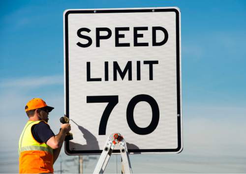 Steve Griffin  |  The Salt Lake Tribune

UDOT's Stephan Foster installs a new 70 mph speed limit sign over a 65 mph sign on I-80 near 5600 west in Salt Lake City, Monday, December 8, 2014.