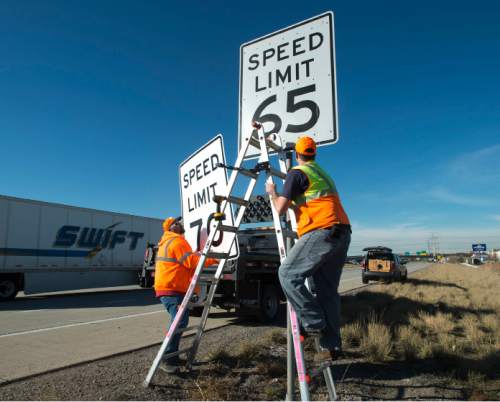 Steve Griffin  |  The Salt Lake Tribune

UDOT's Jayson Kesler, left, and Stephan Foster install a new 70 mph speed limit sign over a 65 mph sign on I-80 near 5600 west in Salt Lake City, Monday, December 8, 2014.
