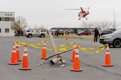 Trent Nelson  |  The Salt Lake Tribune
The tail rotor from a crashed helicopter sits roped off in a parking lot as a medical helicopter takes off at the scene of a helicopter crash near 500 West 900 North in North Salt Lake, Tuesday December 2, 2014.