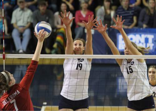 Rick Egan  | The Salt Lake Tribune 

Kierra Holst spikes the ball for the Oklahoma, as Jennifer Hamson (19) and Nicole Warner (15) defend for the Cougars, as BYU faced Oklahoma in NCAA  volleyball action at the Smith Fieldhouse in Provo, Saturday, December 1, 2012.
