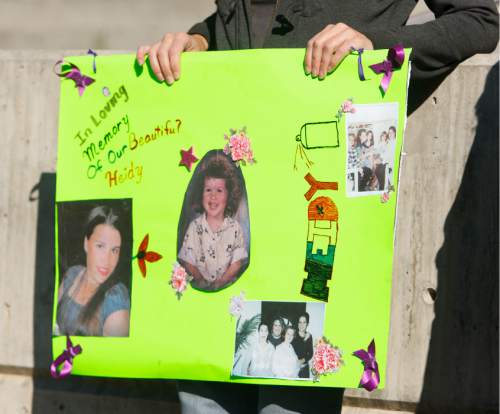 Trent Nelson  |  The Salt Lake Tribune
Autumn Wagner holds a sign memorializing her sister, Heidy Truman, who was killed last year. City officials and community members planted daffodils at the Public Safety Building in Salt Lake City Tuesday, October 15, 2013 in support of YWCA's Week Without Violence.