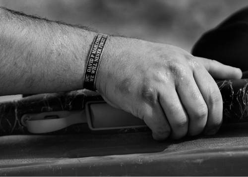 Scott Sommerdorf   |  The Salt Lake Tribune
Bryant Jacobs wears a KIA (killed in action) bracelet honoring Army Spc. David Mahlenbrock who died in the IED blast that injured Jacobs in Iraq, 13/3/04. Jacobs was reaching for a rifle he was using for target practice during an outing at the Castle Valley Outdoors Wing Shooting Lodge, Tuesday, October 7, 2014.