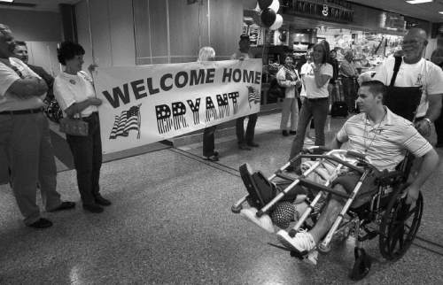 Paul Fraughton  |  The Salt Lake Tribune
Spc. Bryant Jacobs is wheeled past a sign as he is welcomed home by family and friends at Salt lake International Airport, Friday, June 10, 2005.