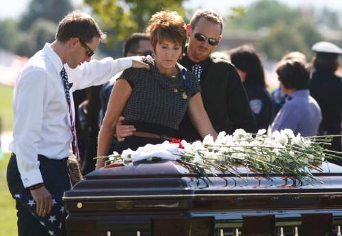 Leah Hogsten | The Salt Lake Tribune
Laura Johnson (center) is comforted by her son Darin Johnson (right) at the casket of her son, Draper Police Sgt. Derek Johnson who was laid to rest at Larkin Sunset Mortuary, September 6, 2013. Sgt. Johnson was shot by a transient after the 32-year-old officer pulled up in his patrol car to investigate the man's vehicle. The suspect, Timothy Troy Walker, then shot his passenger, Traci Vaillancourt, and himself.