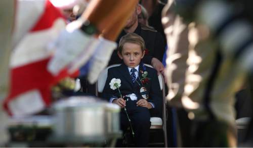 Leah Hogsten | The Salt Lake Tribune
Ben Johnson, 6, watches as Draper police officers fold the flag draping his father Sgt. Derek Johnson's casket. Johnson was laid to rest at Larkin Sunset Mortuary, September 6, 2013. Sgt. Johnson was shot by a transient after the 32-year-old officer pulled up in his patrol car to investigate the man's vehicle. The suspect, Timothy Troy Walker, then shot his passenger, Traci Vaillancourt, and himself.