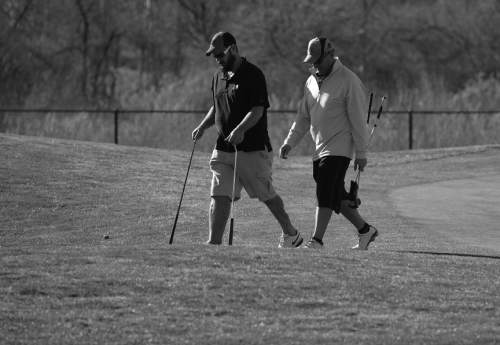 Scott Sommerdorf   |  The Salt Lake Tribune
Bryant Jacobs walks with the help of two golf clubs while playing a round of golf with his friend Tony Korologos at the River Oaks Golf Course in Sandy, Tuesday, February 25, 2014.