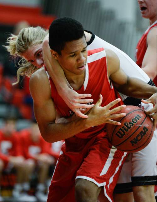 Francisco Kjolseth  |  The Salt Lake Tribune
West High's Xavier Matheson tries to reach in for a ball held by Taj Williams of East High in the Panthers Classic tournament between the two rival schools at West.