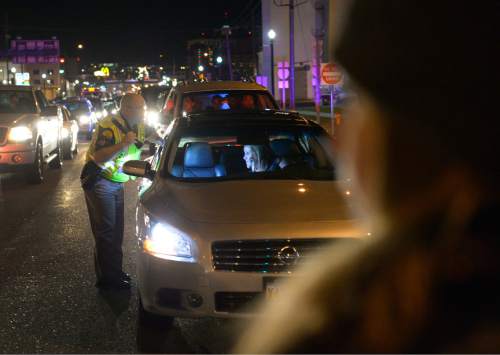 Leah Hogsten  |  The Salt Lake Tribune
A Utah Highway Patrol officer tries to get a motorist to turn off of 600 South to get traffic moving again. Traffic throughout Salt Lake City's streets came to a halt Friday, December 19, 2014 as 40 some protesters with Activist's Corner walked on city streets chanting and holding signs against police brutality during their Merry X - Mas! Shut It Down march. 
The group started outside the Salt Lake City Federal Building, marched down State Street to 600 South and then stopped traffic on both the I-15 on-ramp and the 500 South off ramp in solidarity with the national  movements against violent criminal police.
