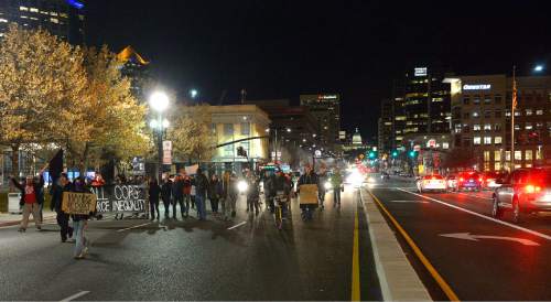 Leah Hogsten  |  The Salt Lake Tribune
Traffic throughout Salt Lake City's streets came to a halt Friday, December 19, 2014 as 40 some protesters with Activist's Corner walked on city streets chanting and holding signs against police brutality during their Merry X - Mas! Shut It Down march. 
The group started outside the Salt Lake City Federal Building, marched down State Street to 600 South and then stopped traffic on both the I-15 on-ramp and the 500 South off ramp in solidarity with the national  movements against violent criminal police.