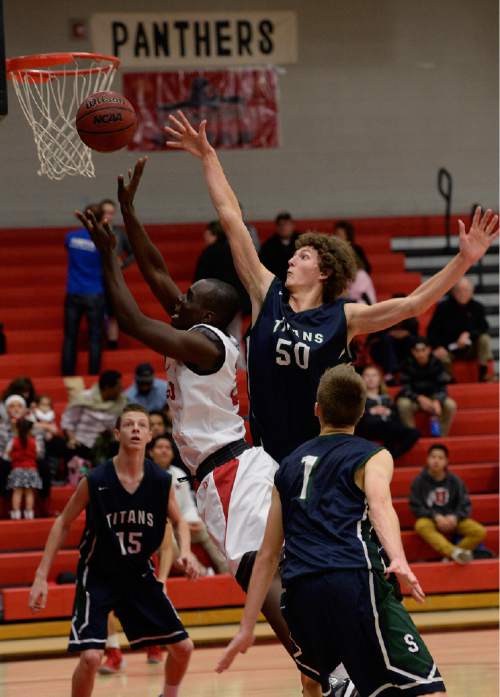 Scott Sommerdorf   |  The Salt Lake Tribune
Syracuse's Kalvin Mudrow blocks a shot by West's James Kauli during second half play. Syracuse beat West 52-51 at the West High Holiday Classic Tournament, Friday, December 19, 2014.