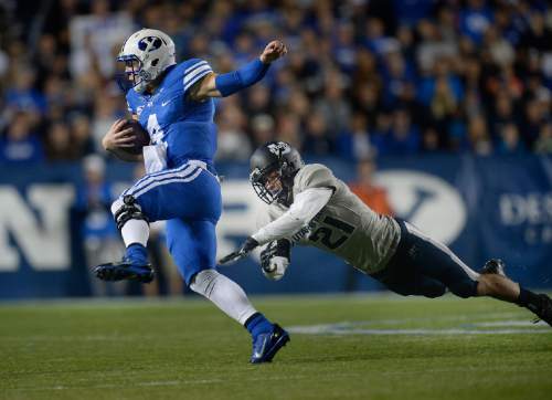 Scott Sommerdorf  |  The Salt Lake Tribune
BYU QB Taysom Hill runs and eludes Utah State Aggies safety Brian Suite (21) during first half play. He later would run a similar play and be injured on a tackle by Suite. Utah State led BYU 28-14 at the half in Provo, Friday, October 1, 2014.