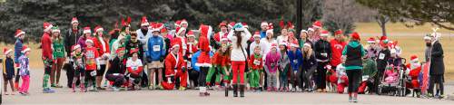 Trent Nelson  |  The Salt Lake Tribune
Runners pose for a group photo at the start of the Santa Hat Dash 5K in Sugar House Park, Salt Lake City, Saturday December 20, 2014. The run encourages Santa hats and costumes --reindeer, snowmen, elves, etc. Participants also donated warm clothing, blankets and toiletries to The Road Home Shelter.