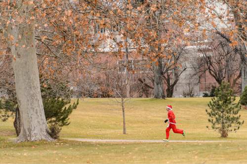 Trent Nelson  |  The Salt Lake Tribune
Ruti Thomas runs in the Santa Hat Dash 5K in Sugar House Park, Salt Lake City, Saturday December 20, 2014. The run encourages Santa hats and costumes --reindeer, snowmen, elves, etc. Participants also donated warm clothing, blankets and toiletries to The Road Home Shelter.