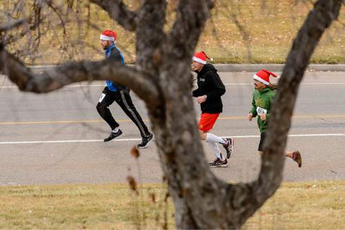 Trent Nelson  |  The Salt Lake Tribune
Runners in the Santa Hat Dash 5K in Sugar House Park, Salt Lake City, Saturday December 20, 2014. The run encourages Santa hats and costumes --reindeer, snowmen, elves, etc. Participants also donated warm clothing, blankets and toiletries to The Road Home Shelter.