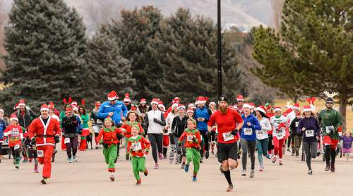 Trent Nelson  |  The Salt Lake Tribune
Runners take off at the start of the Santa Hat Dash 5K in Sugar House Park, Salt Lake City, Saturday December 20, 2014. The run encourages Santa hats and costumes --reindeer, snowmen, elves, etc. Participants also donated warm clothing, blankets and toiletries to The Road Home Shelter.