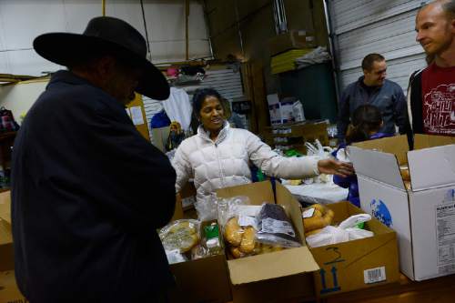 Scott Sommerdorf   |  The Salt Lake Tribune
Volunteer Marci Draper shows the choices of food boxes to a man at the Salt Lake City Mission, Saturday, December 20, 2014. The Mission was prepared to give out 1,000 Christmas food boxes to help Utahns in need for the holidays. , Saturday, December 20, 2014.