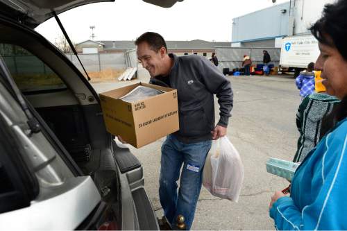 Scott Sommerdorf   |  The Salt Lake Tribune
Volunteer Myron Vawdrey, helps load donated food including a frozen turkey into the back of a woman's car at The Salt Lake City Mission, Saturday, December 20, 2014. The Mission was prepared to give out 1,000 Christmas food boxes to help Utahns in need for the holidays. Saturday, December 20, 2014.