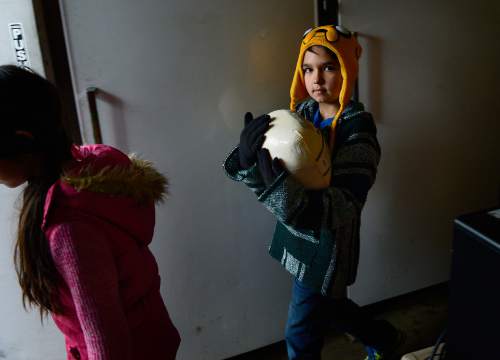 Scott Sommerdorf   |  The Salt Lake Tribune
Nine-year-old volunteer Hawkin Vawdrey, carries a frozen turkey to the car of a client of The Salt Lake City Mission, Saturday, December 20, 2014. The Mission was prepared to give out 1,000 Christmas food boxes to help Utahns in need for the holidays. Saturday, December 20, 2014.