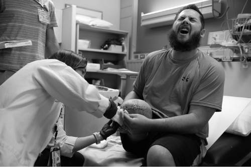 Scott Sommerdorf   |  The Salt Lake Tribune
Bryant Jacobs reacts in pain as Doctor Dana Johns removes some stitches, Friday, April 11, 2014.