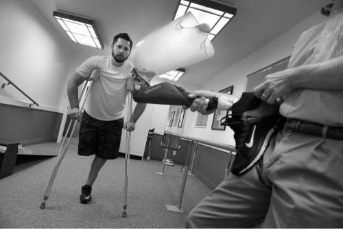 Scott Sommerdorf   |  The Salt Lake Tribune
Prosthetist Lane Ferrin shows Bryant the prosthetic he has made for him worth the Genium knee at Northwest Orthotics and Prosthetics in Provo, Monday, June 16, 2014.