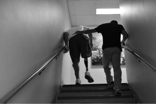 Scott Sommerdorf   |  The Salt Lake Tribune
Bryant Jacobs practices walking up and down stairs at the VA with physical therapist Bart Gillespie, Wednesday, July 16, 2014.