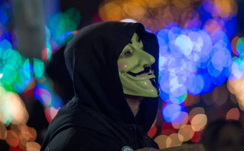 Rick Egan  |  The Salt Lake Tribune

Matt Champion wears a mask as he holds a sign with group of people protesting against police violence, in front of the Ogden Police Station ,Saturday, December 20, 2014