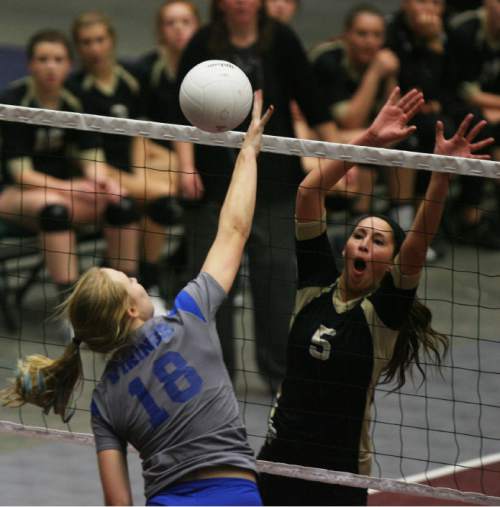 Kim Raff | The Salt Lake Tribune
(left) Lone Peak player Emily Lewis blocks as Pleasant Grove player Madison Wolford hits the ball during the 5A state volleyball championship at UCCU Center on the UVU campus in Orem, Utah on November 3, 2012.