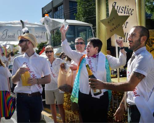 Scott Sommerdorf   |  The Salt Lake Tribune
Kate Call, center, raises her glass as Moudi Sbeity, right, pops a bottle of champagne as his spouse, Derek Kitchen, left celebrates with the group at the marriage float just prior to the Salt Lake City Pride Parade, Sunday, June 7, 2014.