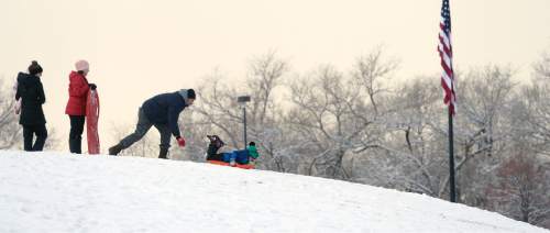 Al Hartmann  |  The Salt Lake Tribune
Family take advantage of the day-after-Christmas extended vacation with sledding on the new snow in Liberty Park Friday Dec. 26.