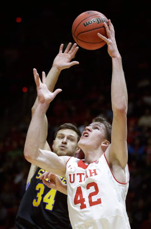 Utah forward Jakob Poeltl (42) catches a pass as South Dakota State forward Cody Larson (34) defends in the second half during an NCAA college basketball game Tuesday, Dec. 23, 2014, in Salt Lake City. (AP Photo/Rick Bowmer)