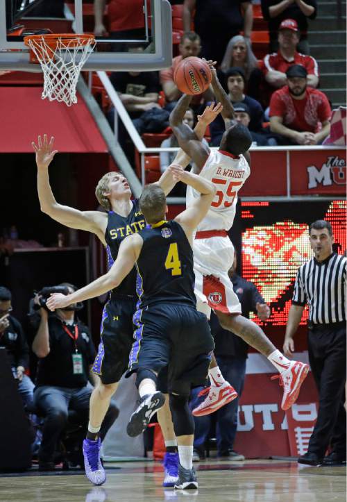 South Dakota State forward Connor Devine and guard Jake Bittle (4) defend against Utah guard Delon Wright (55) in the first half during an NCAA college basketball game Tuesday, Dec. 23, 2014, in Salt Lake City. (AP Photo/Rick Bowmer)