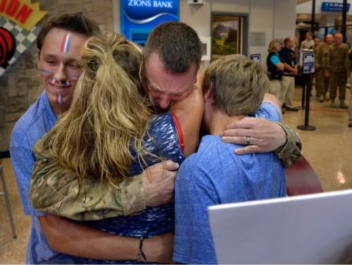 Scott Sommerdorf   |  The Salt Lake Tribune
Sgt. Major Thayne Turegon is surrounded by his family including his son Kaden, at left, as he is welcomed back along with other Utah National Guard soldiers as they returned home Saturday from a 12-month deployment to Afghanistan. Members of the Guardís 65th Field Artillery Brigade were greeted by their loved ones at Salt Lake City International Airport on Saturday.
