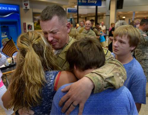 Scott Sommerdorf   |  The Salt Lake Tribune
Sgt. Najor Thayne Turgeon reacts as he holds his family in his arms after a 12-month deployment to Afghanistan. Members of the Guard's 65th Field Artillery Brigade were greeted by their loved ones at Salt Lake City International Airport, Saturday, May 31, 2014.