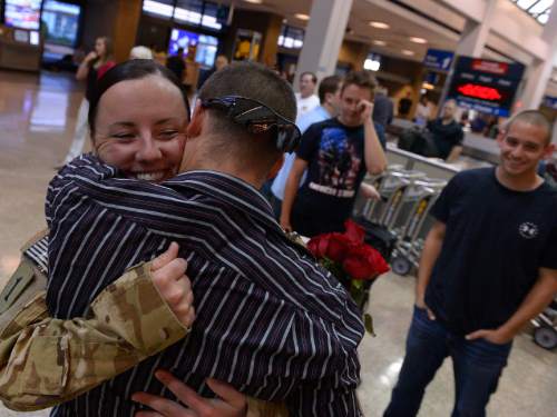 Leah Hogsten  |  The Salt Lake Tribune
Spc Jennifer Davis hugs her husband Kristopher Davis after arriving home with eight other members of her battalion.  Utah Army National Guard's 211th Aviation Regiment returned home to Utah after a 10-month deployment to Afghanistan on Sunday, September 7, 2014 at the Salt Lake International Airport. The mission of the soldiers from the 1st Battalion 171st Aviation was to provide air medical evacuation, or 'MEDEVAC' support for friendly forces in Afghanistan. A total of 16 soldiers returned home today.