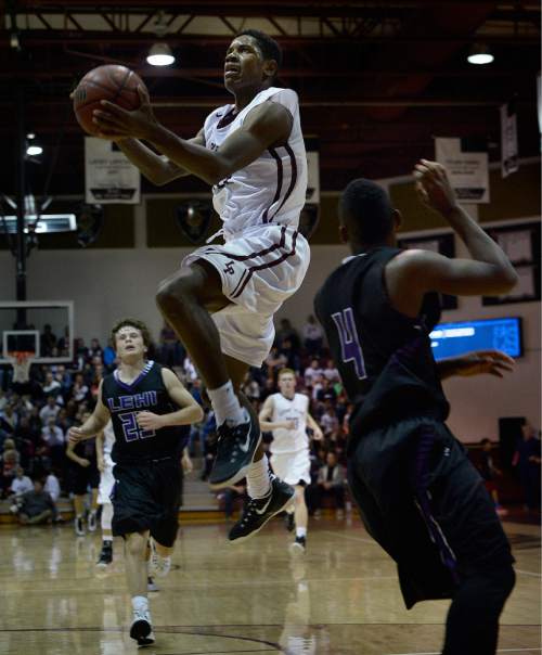 Scott Sommerdorf   |  The Salt Lake Tribune
Lone Peak's Christian Popoola leaps past the defense of Lehi's Marcus Draney for a layup during first half play. Lone Peak held a 44-38 lead over Lehi at the half, and won 84-72, Friday, January 9, 2015.
