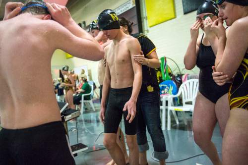 Chris Detrick  |  The Salt Lake Tribune
Assistant coach Abi Schofield helps sophomore Kale Walker onto the starting block before swimming warm up laps at Wasatch High School Swimming Pool Thursday January 15, 2015.  Walker has been blind since birth and this is his first year on the Wasatch swim team.