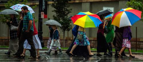 Chris Detrick  |  The Salt Lake Tribune
Pedestrians attempt to stay dry under umbrellas while crossing South Temple Street in Salt Lake City Saturday September 27, 2014.