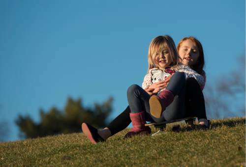Rick Egan  |  The Salt Lake Tribune

Kaia Durocher, 4, and Gracey Kelly, 6, ride a skateboard down the hill at Liberty Park, as they enjoy the warm December weather Saturday, December 6, 2014