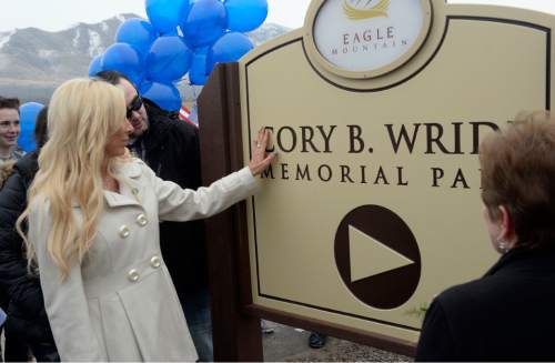 Al Hartmann  |  The Salt Lake Tribune
Nanette Wride, widow of Cory Wride touches her hand to sign at First Anniversary Memorial Event and Park Dedication for Utah County Sheriff Sgt. Cory Wride, who was fatally shot in the line of duty on Jan. 30, 2014.   
Eagle Mountain City renamed Mid-Valley Regional Park as Cory B. Wride Memorial Park so that Sgt. Wride's service and sacrifice will always be remembered.
