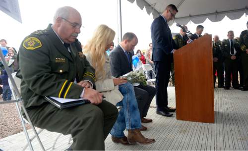 Al Hartmann  |  The Salt Lake Tribune
Utah County Sheriff Jim Tracy, Nanette Wride, Utah Lt. Governor Spencer Cox and Eagle Mountain Mayor Chris Pengra lead group in a moment of silence at First Anniversary Memorial Event and Park Dedication for Utah County Sheriff Sgt. Cory Wride, who was fatally shot in the line of duty on Jan. 30, 2014.   
Eagle Mountain City renamed Mid-Valley Regional Park as Cory B. Wride Memorial Park so that Sgt. Wride's service and sacrifice will always be remembered.