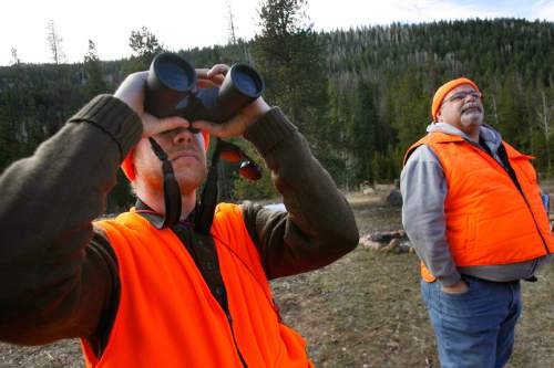 Scott Sommerdorf  |  The Salt Lake Tribune              
Nicholas Smith, left, scans the hillsides near Kamas for deer as Shawn Gehring, right, looks on, Saturday, October 19, 2012. The general season rifle deer hunt opened at dawn Saturday with a new format that limits hunters to one of 30 units instead of one of five regions in the state. More than 52,000 are expected to be in the field.