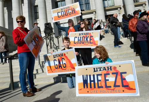 Scott Sommerdorf   |  The Salt Lake Tribune
Nurses Elisa Morrill, left, and Cheyrl Shelley, holding COUGH sign, attended the rally with signs describing the Utah air at the Clean Air, No Excuses Rally, Saturday, Jan. 31, 2015. Spencer Morrill, holds GAG, and Ivy Frampton holds WHEEZE.