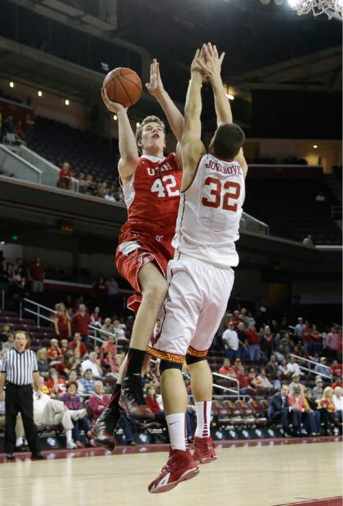 Utah's Jakob Poeltl, left, of Austria, shoots under pressure by Southern California's Nikola Jovanovic, of Serbia, during the first half of an NCAA college basketball game, Sunday, Feb. 1, 2015, in Los Angeles. (AP Photo/Jae C. Hong)
