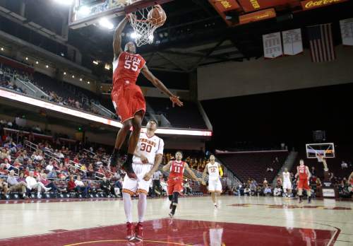 Utah's Delon Wright, top, dunks as Southern California's Elijah Stewart looks on during the first half of an NCAA college basketball game, Sunday, Feb. 1, 2015, in Los Angeles. (AP Photo/Jae C. Hong)