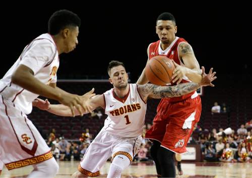 Southern California's Katin Reinhardt, center, and Utah's Jordan Loveridge, right, fight for a loose ball as Southern California's Elijah Stewart watches during the first half of an NCAA college basketball game, Sunday, Feb. 1, 2015, in Los Angeles. (AP Photo/Jae C. Hong)