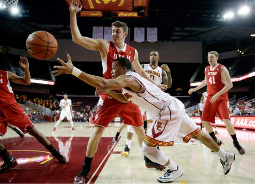 Southern California's Chass Bryan, front, passes the ball as he is defended by Utah's Austin Eastman during the second half of an NCAA college basketball game, Sunday, Feb. 1, 2015, in Los Angeles. Utah won 67-39. (AP Photo/Jae C. Hong)