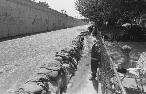 Al Hartmann  |  The Salt Lake Tribune

Children play in a front yard along North Temple  which was sandbagged forming a "river" in late May 1983 during massive flooding.