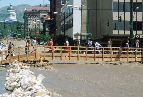 Al Hartmann  |  The Salt Lake Tribune

Pedestrians use a bridge to cross State Street in Salt Lake City during the heavy floods in June 1983.